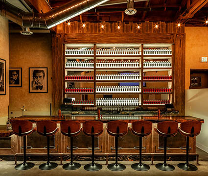 Destilleriets whiskey, gin og vodka står på snorlige rækker i baren. Foto: Jakob Layman.